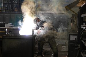 Man Wearing Gray Shirt And Welding Mask Covered In Welding 2760344